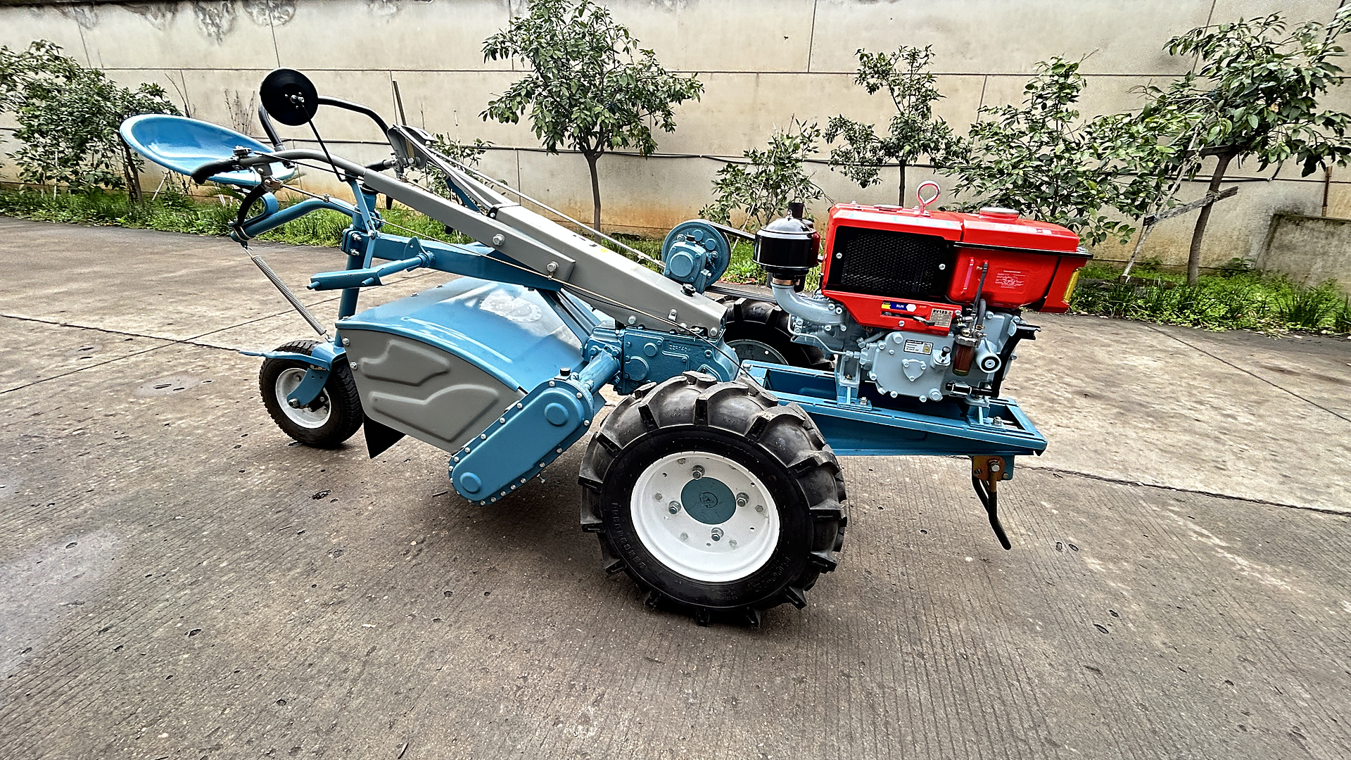 A complete SUNTEC two-wheel walking tractor with its diesel engine and rotary tiller housing, photographed on the yard before delivery